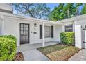 Inviting front entrance with a modern door, stylish lighting, and well-manicured landscaping at 1850 Shawnee Trl, Maitland, FL 32751