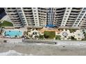 Aerial view of a luxury condo building highlighting its pool, deck, and beach access at 1925 S Atlantic Ave # 411, Daytona Beach, FL 32118