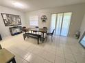 Bright dining room with a modern table set, a decorative mirror, and sliding glass doors to a patio at 2357 Rio Pinar Lakes Blvd, Orlando, FL 32822