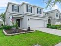 Charming two-story home featuring a well-manicured lawn, gray stucco exterior, and attached two-car garage at 2620 Waterline St, Kissimmee, FL 34743
