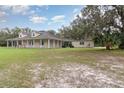 Single-story home with a wraparound porch and expansive green lawn surrounded by mature trees at 2691 Phillips Rd, Christmas, FL 32709