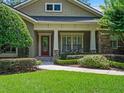 Charming home exterior with a well-manicured lawn, stone accents, and a welcoming front porch with seating at 2750 Lee Shore Loop, Orlando, FL 32820