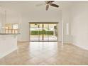 Open-concept living area with tile flooring and sliding glass doors to the screened patio at 289 Laurenburg Ln, Ocoee, FL 34761