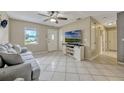 Bright living room with tile flooring, ceiling fan, and large TV for comfortable living at 2943 Slippery Rock Ave, Orlando, FL 32826