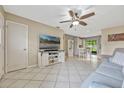 Open living room features tile floors, neutral decor, a ceiling fan and a view to the kitchen at 2943 Slippery Rock Ave, Orlando, FL 32826