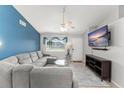 Comfortable living room with a plush gray sectional, light-colored walls, and a large window at 3232 Butterfield St, Deltona, FL 32738