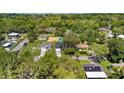 Aerial view of a modern home nestled among lush greenery with a manicured lawn at 3672 Rollin O Ln, Apopka, FL 32703