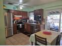 Well-lit kitchen featuring stainless steel appliances, wood cabinets, and tile floors at 4123 Gander Ave, Orlando, FL 32822