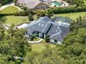 Beautiful home with a black roof, complemented by mature trees and a manicured lawn at 4454 Aspenwood Ct, Orlando, FL 32835