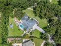Luxurious home with a screened pool, surrounded by lush landscaping and mature trees at 4454 Aspenwood Ct, Orlando, FL 32835