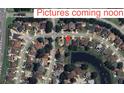 Aerial view of a residential neighborhood with tree-lined streets and a small pond at 451 Acacia Tree Way, Kissimmee, FL 34758