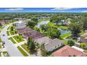 Aerial view of a residential neighborhood with houses surrounding a serene pond at 451 Acacia Tree Way, Kissimmee, FL 34758