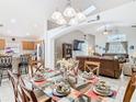 Elegant dining room with a glass table, and a view into the kitchen and living room at 512 Viola Dr, Davenport, FL 33837