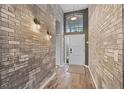 Inviting entryway with brick walls, hardwood flooring, and a modern front door at 545 Hardwood Cir, Orlando, FL 32828