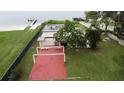 Aerial view of the property showing its backyard with patio, lush lawn, and lakefront access with dock at 5529 Hansel Ave, Orlando, FL 32809