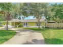 A well-maintained home featuring a long driveway, lush lawn, and mature trees providing shade and privacy at 700 E Mattie St, Sanford, FL 32773