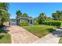 Attractive single-story home with lush landscaping, a brick driveway, and a beautifully manicured lawn at 725 S Hampton Ave, Orlando, FL 32803