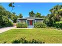 Inviting single-story home featuring lush landscaping, a vibrant lawn, and a brick-paved driveway at 725 S Hampton Ave, Orlando, FL 32803
