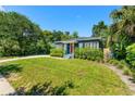 Lovely single-story home with a well-maintained lawn, mature trees, and a charming red front door at 725 S Hampton Ave, Orlando, FL 32803