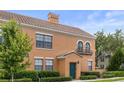 Charming two-story home with tile roof, green door, manicured landscaping, and stucco siding at 730 Siena Palm Dr # 201, Celebration, FL 34747