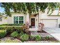A lovely front entrance with a red door and nicely maintained landscaping at 750 Maple Leaf Loop, Winter Springs, FL 32708