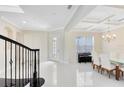 Inviting foyer featuring elegant staircase, sleek tile flooring, and a dining area with piano adding sophistication at 8480 Adalina Pl, Orlando, FL 32827