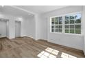 Sunlit living area with new flooring and white trim; showcases a bright, airy atmosphere at 906 Kensington Dr, Orlando, FL 32808