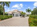 Beautiful exterior shot with large driveway, lush landscaping, and a three-car garage at 9138 Great Heron Cir, Orlando, FL 32836