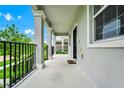 Inviting covered porch featuring stately columns and black railings, perfect for outdoor relaxation at 9909 Alliteration Aly, Winter Garden, FL 34787
