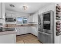 Updated kitchen featuring white cabinets, stainless steel appliances, and a functional layout, with a view to the front window at 1328 Vassar St, Orlando, FL 32804