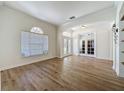 Bright living room showcasing hardwood floors, an arched entrance, and a decorative front door at 14044 Chicora Crossing Blvd, Orlando, FL 32828