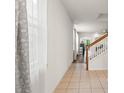 Hallway with tile flooring and a staircase leading to the upper level at 14213 Turning Leaf Dr, Orlando, FL 32828