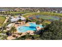 Aerial view of community pool and amenity center overlooking a scenic pond at 15477 Blackbead St, Winter Garden, FL 34787