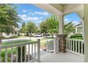 Inviting front porch with stone columns, white railing, and serene neighborhood views at 15477 Blackbead St, Winter Garden, FL 34787