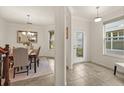 Inviting foyer with tile flooring, a decorative front door and entry to formal dining room at 1613 Water Elm Ct, Orlando, FL 32825