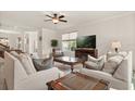 Cozy living room with a ceiling fan, plush sofas, and a large window at 1613 Water Elm Ct, Orlando, FL 32825