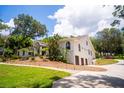Beautiful home with arched windows, a three-car garage, and a well-maintained lawn at 16400 Lakeshore Dr, Minneola, FL 34715