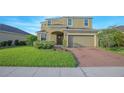 Charming two-story home with a well-manicured lawn and a two-car garage at 171 Seville Dr, Davenport, FL 33837