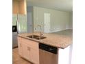 Kitchen island with granite countertop, stainless steel sink, and stainless steel dishwasher at 17305 Cagan Crossings Blvd, Clermont, FL 34714