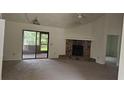 Spacious living room featuring a stone fireplace and sliding glass doors at 2008 Juniper Dr, Edgewater, FL 32141