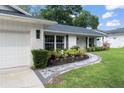 Charming home featuring a freshly painted brick exterior, a garage, and a beautifully landscaped walkway at 207 Ramsbury Ct, Longwood, FL 32779