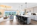 Modern, open-concept kitchen with large island, pendant lighting and a view of the living room at 2267 Mossy Vine Ave, St Cloud, FL 34771