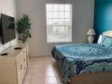 Bright bedroom with a TV, tile floor, dresser, and bright window with natural light at 2305 Butterfly Palm Way # 304, Kissimmee, FL 34747