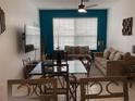 Inviting living area with neutral colored couches, tile floor, modern decor, and a large bright window at 2305 Butterfly Palm Way # 304, Kissimmee, FL 34747