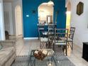 Living area with modern furniture, dining table, tile floor, and bright blue accent wall at 2305 Butterfly Palm Way # 304, Kissimmee, FL 34747