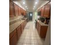 Spacious kitchen featuring tile flooring, granite countertops, and wooden cabinets at 2500 21St Nw St # 58, Winter Haven, FL 33881