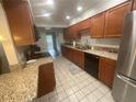 A kitchen featuring granite countertops, wood cabinets, and stainless steel appliances at 2500 21St Nw St # 58, Winter Haven, FL 33881