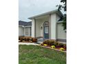 Inviting front porch with a stylish blue door and decorative landscaping enhancing the curb appeal of this lovely home at 2864 Trenton Ln, Deltona, FL 32738