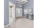Bright foyer featuring a tray ceiling, white tile floors, and a modern console table at 3281 Saloman Ln, Clermont, FL 34711
