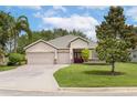 Well-maintained single-story home with a three-car garage, landscaped yard, and inviting front entrance at 3281 Saloman Ln, Clermont, FL 34711